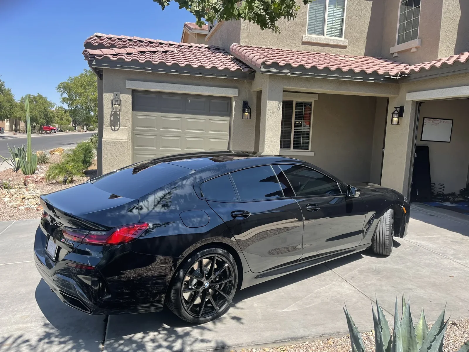 Black sedan with tinted windows parked in a residential driveway